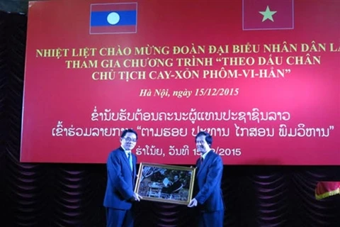 河内理工大学向老挝人民代表团团长维莱冯.博嗒堪移交凯山.丰威汉的照片（图片来源：人民军队报）