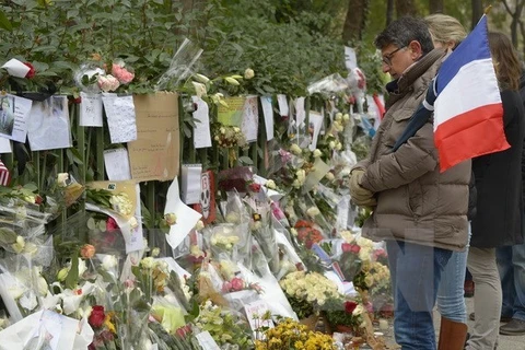 法国巴黎恐怖袭击后，人们在共和广场献花，哀悼罹难者（图片来源：法新社）