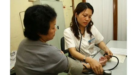 海防市吴权郡卫生中心的医生为老年人看病（图片来源：人民报）