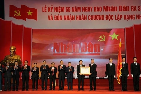丁世兄同志代表党和国家领导人向《人民报》社授予一级独立勋章。（图片来源：人民报网）