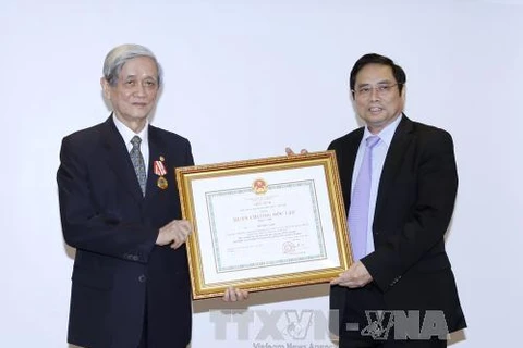 范明政部长向原越通社社长胡进毅授予一级独立勋章（图片来源：越通社）