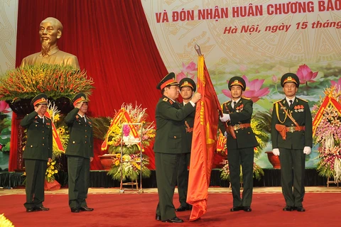 国防部长吴春历大将把一级祖国捍卫勋章佩戴在军医局的决胜旗上（图片来源：越通社）