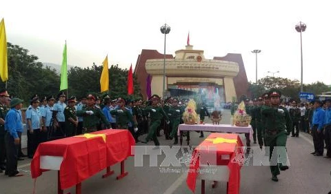 在老挝牺牲的越南志愿军和专家烈士遗骸交接仪式在劳宝国际口岸举行（图片来源：越通社）