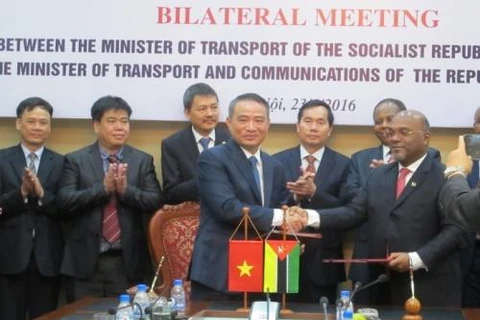 越南交通运输部部长张光义和莫桑比克交通和通讯部部长卡洛斯·梅斯基塔在备忘录签约仪式上亲切握手。