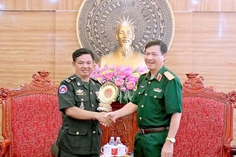 第四军区副司令员兼参谋长邓仲军少将向柬埔寨王家军队干部代表团代表赠送纪念礼物。（图片来源：人民军队报）