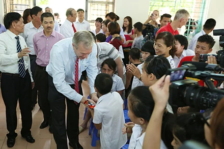 美国驻越大使特德·奥修斯探望慰问越南友谊村橙剂受害者（图片来源：越南劳动报）