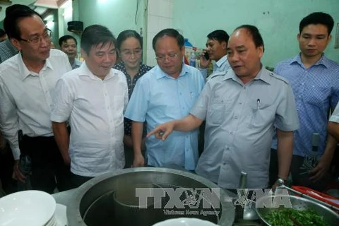越南政府总理阮春福率团走访一家河粉店（图片来源：越通社）