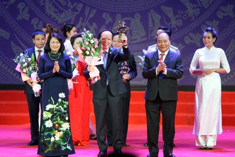 越南国家主席邓氏玉盛和政府总理阮春福向典范企业家授予喠圣奖杯（图片来源：越通社-VNA）