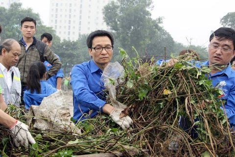 武德儋副总理与河内市青年们参与灵潭湖垃圾清理活动。