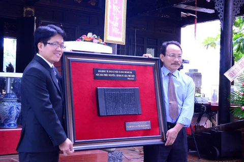 国家档案中心代表向广义省文化体育旅游厅代表授予的越南阮朝木版