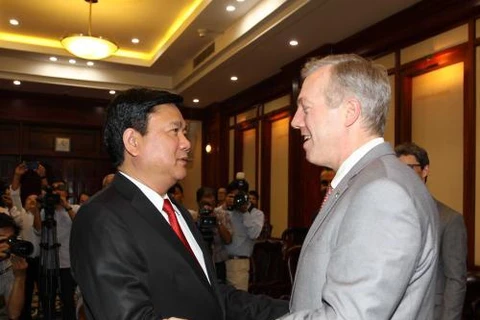 胡志明市委书记丁罗升与美国驻越大使泰德·奥修斯亲切地握手。