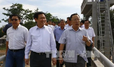王廷惠副总理对后江省胃清市新进乡的暂时挡海坝进行视察。