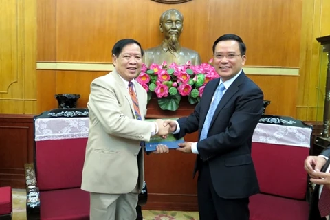 越南祖国阵线中央委员会副主席阮文坡(右向老挝律师代表团团长坎赛·苏林吞赠送礼物