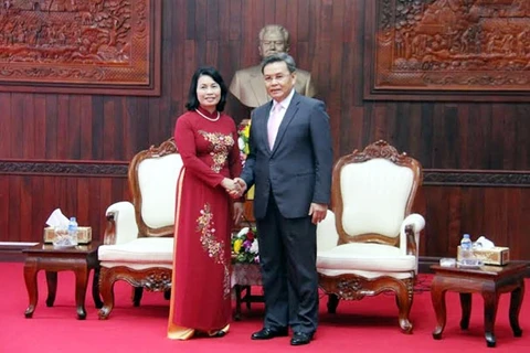 越南祖国阵线中央委员会副主席裴氏青与老挝建国阵线中央委员会副主席占塔翁亲切握手（图片来源：越南人民报）
