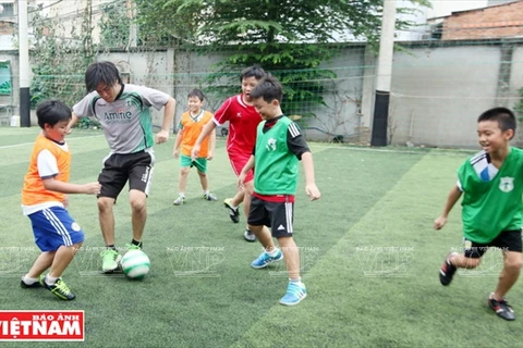 Kitaguchi Haruki与儿童踢足球。