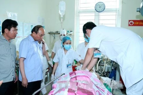 阮春福总理来到医院看望遇难者。（图片来源：越通社）