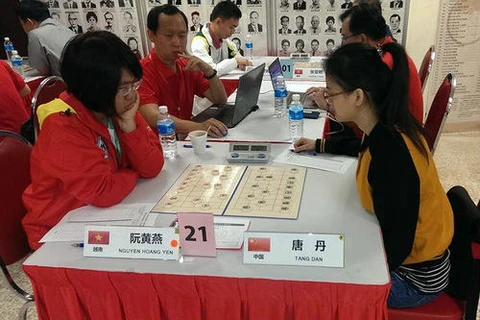 越南棋手阮黄燕在比赛中（左）（图：体育报）