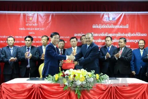 武文赏（左）与吉乔•开坎佩吞（右）签署了2016-2020年阶段越共中央宣教部与老挝人民革命党宣传部间的合作协议。（图片来源：越通社）