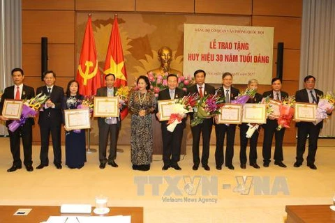 阮氏金银向11位干部、党员授予30周年党龄纪念章（图片来源：越通社）