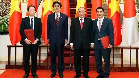 阮春福总理、日本首相安倍晋三、日本国际协力机构和越南财政部代表出席协议签署仪式。