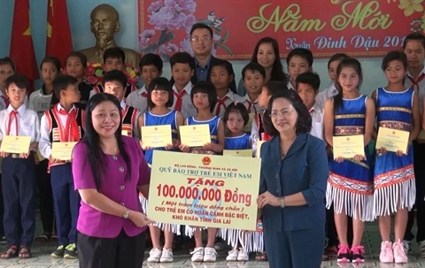 越南国家副主席邓氏玉盛向特困学生颁发助学金（图片来源：越通社）