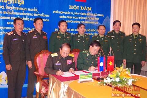 越南与老挝代表团团长签署会议纪要（图片来源：baonghean.vn）
