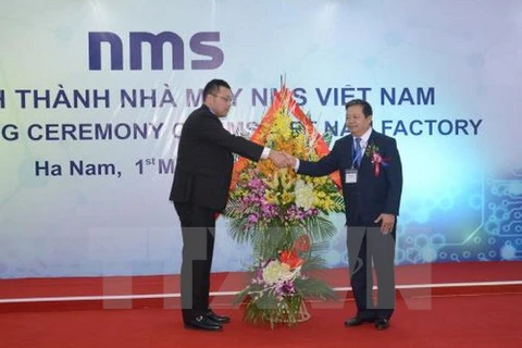 河南省人民委员会主席阮春东向越南NMS公司领导送花（图片来源：越通社）