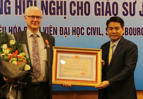 河内市人委会领导向乔尔·勒罗伊教授（左）授予越南国家主席的友谊勋章（图片来源：baomoi.com)