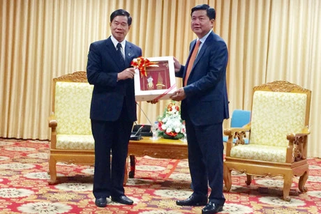 胡志明市委书记丁罗升向老挝万象市委书记兼市长辛拉冯•库派吞互赠纪念品
