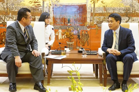 河内市委副书记、市人委会主席阮德钟（右）与日本西条市市长玉井年寿。