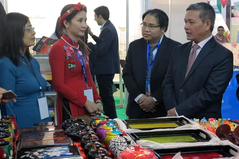 越南驻阿尔及利亚大使范国柱（右）参观越南企业的展位（图片来源：越通社）