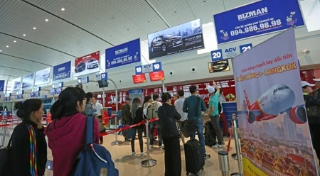 乘客在吉碑机场办理登机手续。（图片来源：越南人民报）