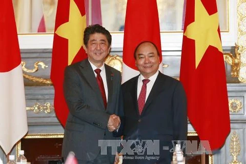 阮春福总理（右）与日本首相安倍晋三。（图片来源：越通社）