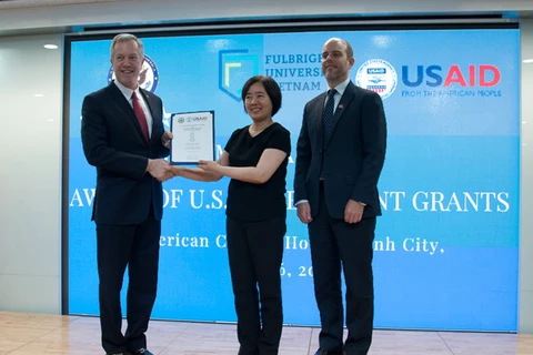 美国驻越大使（左）向颁发越南富布赖特大学校长（左二）颁发援助决定。（图片来源：越通社） 