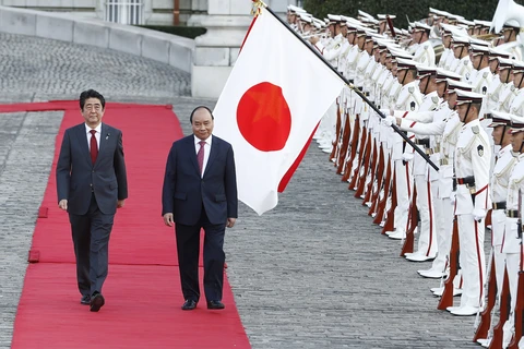 日本首相安倍晋三和越南政府总理阮春福（右）检阅仪仗队。（图片来源：越通社）