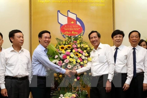 越共中央宣教部部长武文赏向越南新闻工作者协会领导赠送花篮（图片来源：越通社）