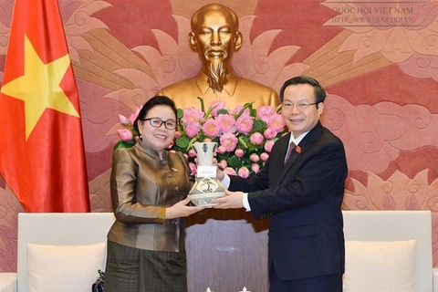 越南国会副主席冯国显（右）向老挝国会司法委员会主任布坎赠送纪念品。
