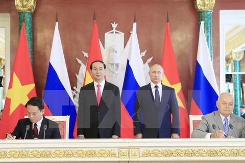陈大光主席和普京总统见证越通社与俄罗斯卫星通讯社新闻互换协议签署仪式。（图片来源：越通社）