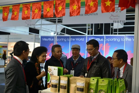 越南驻南非大使武文勇（左四）向参观者介绍越南产品。（图片来源：VOV）