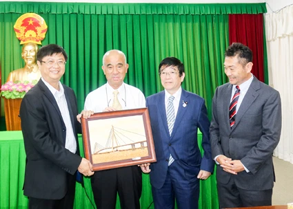 芹苴市人民委员会副主席张光淮南(左一）向长崎县-越南友好协会主席富冈勉赠送纪念品。