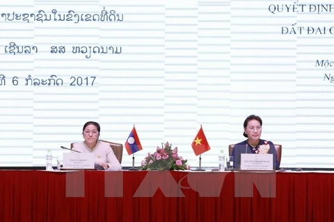 越南国会主席阮氏金银同老挝国会主席巴妮•雅陶都共同主持研讨会。（图片来源：越通社）
