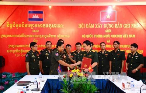 越南国防部法制司司长韩孟胜大校和柬埔寨国防部法制局局长Mom Sophat大将签署会谈纪要。