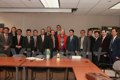 美国商务部副助理部长黛安娜•法雷尔（红衣）与越南代表团合影。（图片来源：越通社）
