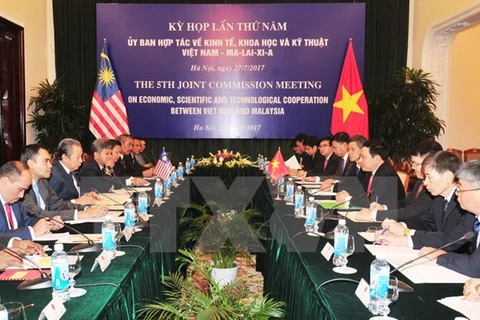 越南外交部长范平明同马来西亚外交部部长阿尼法·阿曼共同主持越马经济、科技混合委员会第五次会议。（图片来源：越通社）