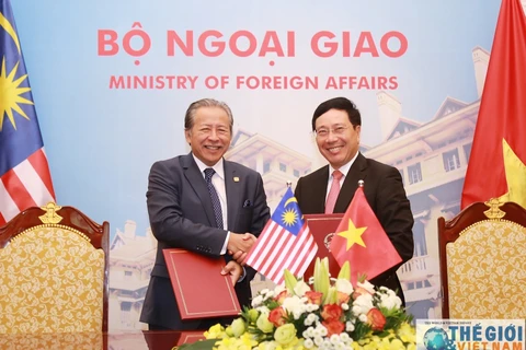 越南政府副总理范平明（右）和马来西亚外交部长阿尼法（图：baoquocte.vn） 