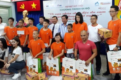 步行活动的赞助商向橙剂受害者赠送慰问品。（图片来源：sggp.org.vn）