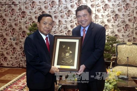 阮成峰（右）向老挝人民革命党中央办公厅主任坎潘·彭玛塔赠送纪念品。