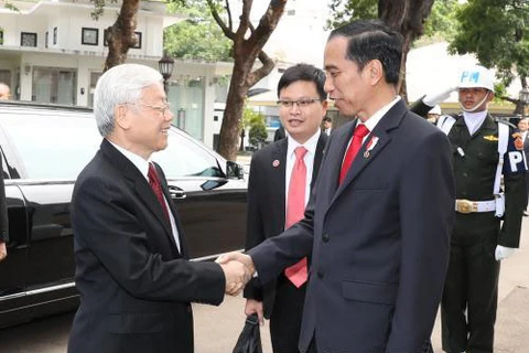 阮富仲总书记与印尼总统佐科·维多多握手。（图片来源：越通社）