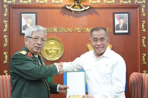 越南国防部副部长阮志咏（左）向印尼国防部长赠送纪念品。