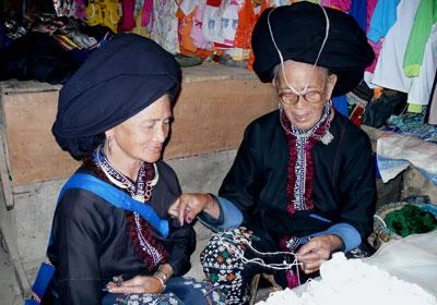 缝瑶族妇女交换挑选刺绣丝线的经验。